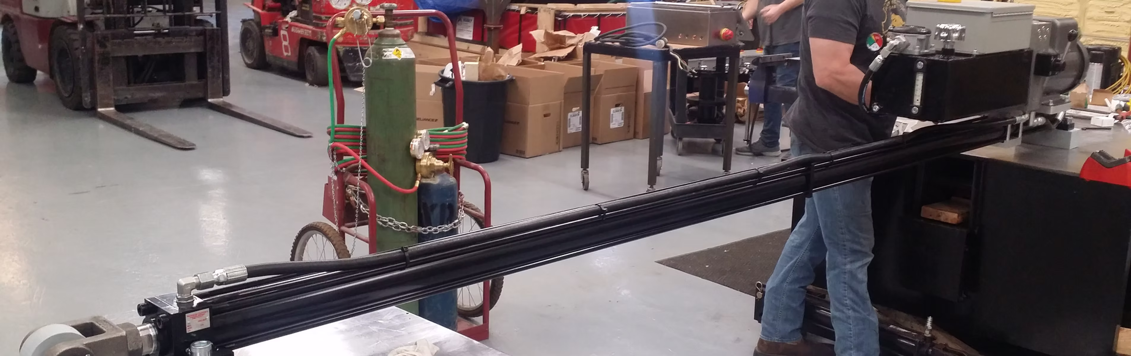 Industrial workshop with welding gas tanks, machinery, and forklift